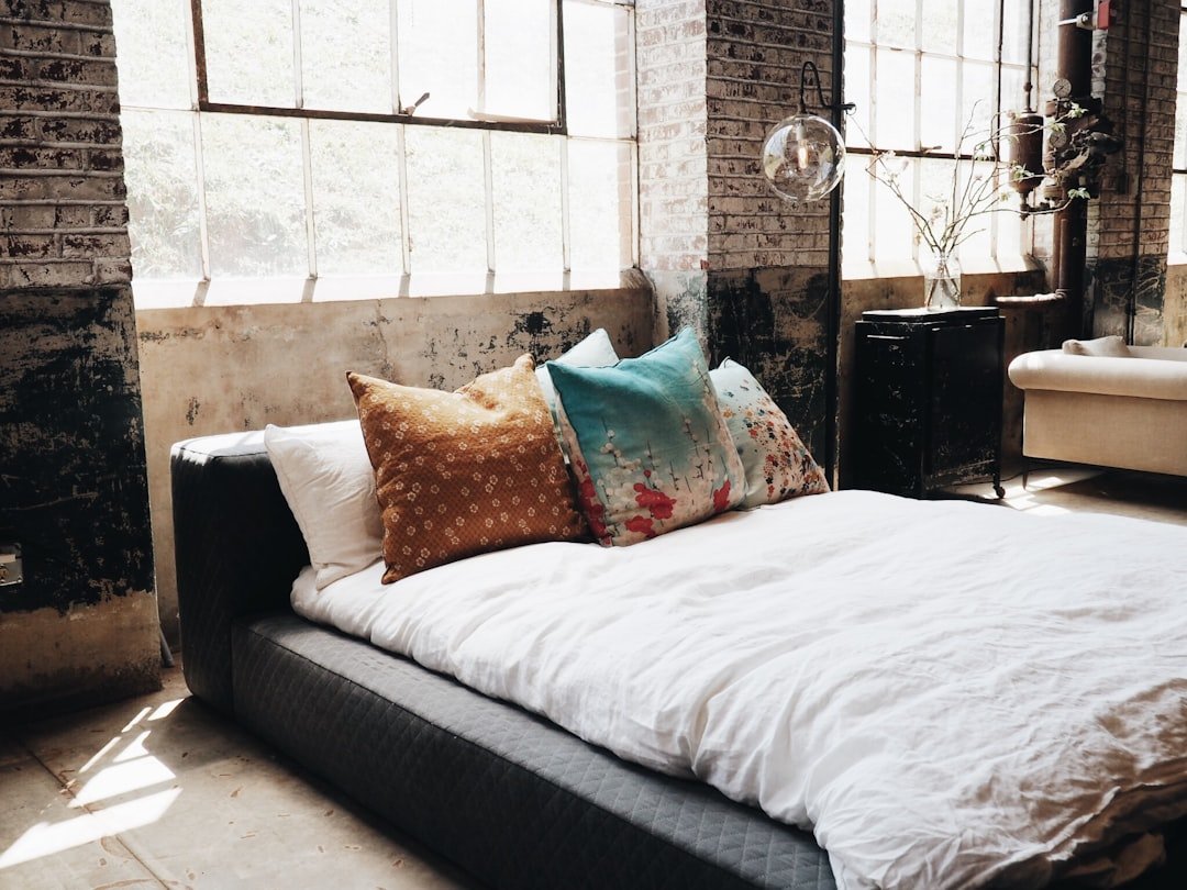 Bohemian bedroom with layered white bedding and textured cushions
