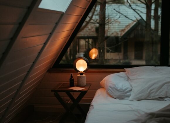 Small Room Lighting Ideas That Make Your Space Feel Bigger A cozy small bedroom lit with a warm bedside lamp creating a welcoming atmosphere