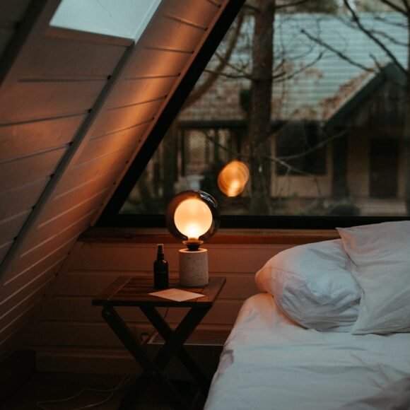 A cozy small bedroom lit with a warm bedside lamp creating a welcoming atmosphere