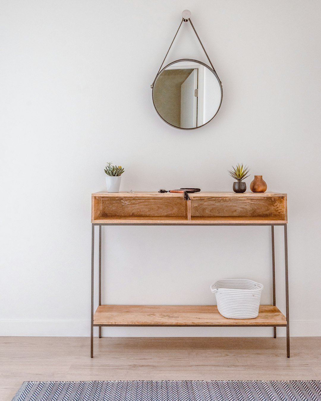 Styled hallway console table with keys, decorative items and a small plant