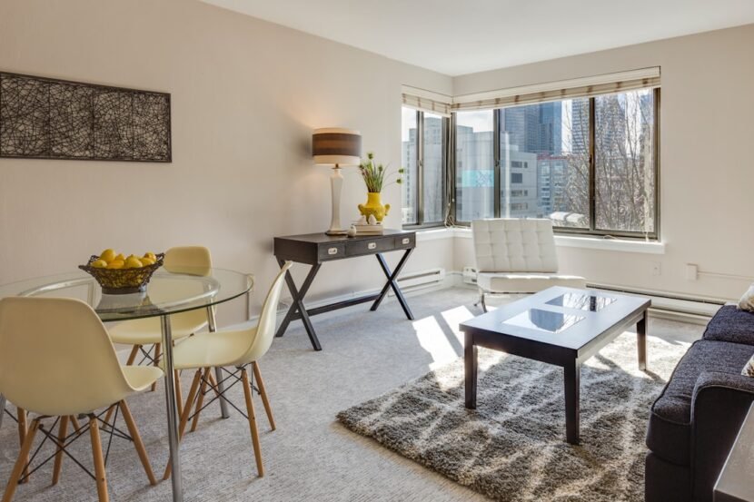 Modern Apartment Living Room Ideas: 20 Ways to Look Good A modern apartment living room with a glass-top dining table, neutral decor, and clean lines in a small space