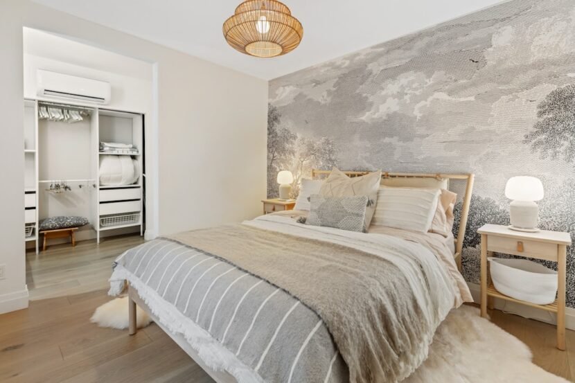 A renter-friendly bedroom decorated with clean white and gray bedding and damage-free decor