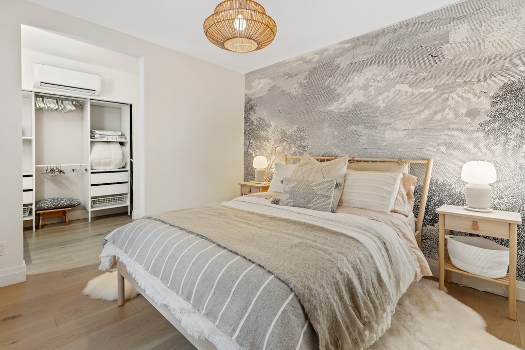 A renter-friendly bedroom decorated with clean white and gray bedding and damage-free decor