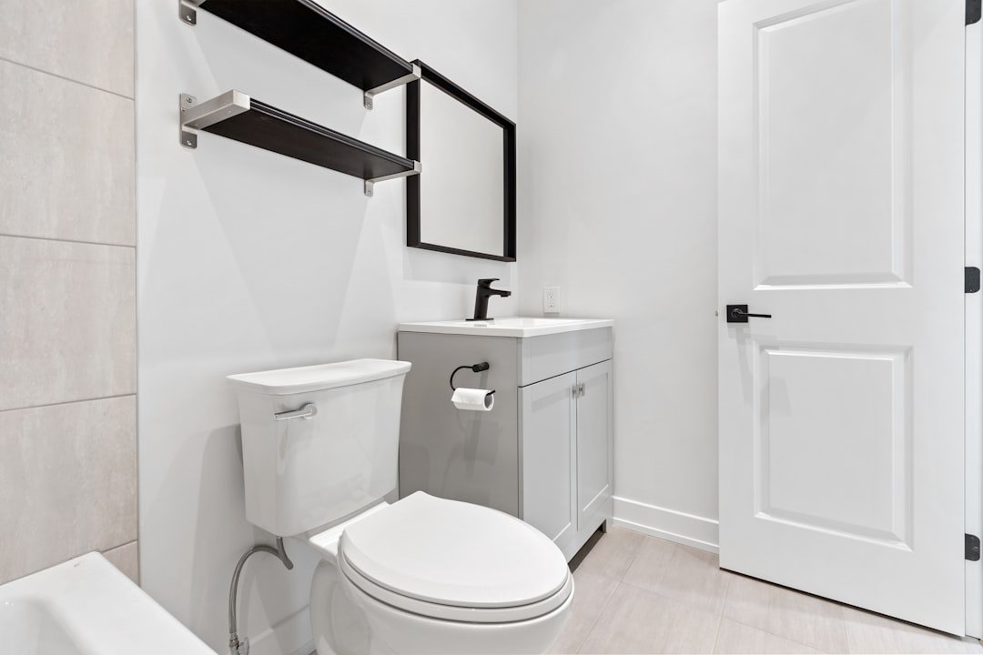 A small apartment bathroom with smart storage solutions including shelving above the toilet