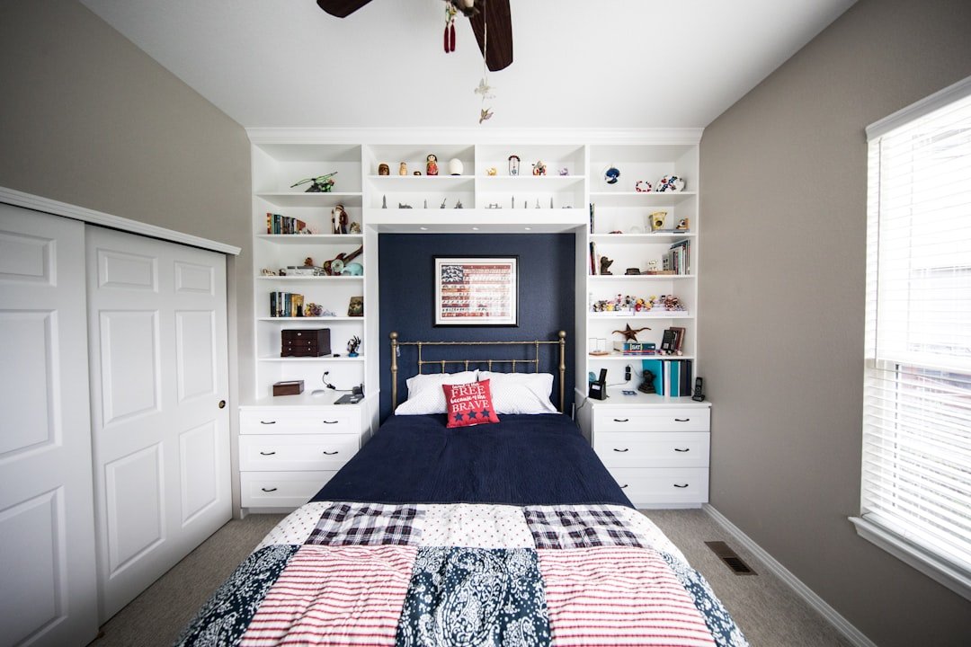 A small bedroom with smart storage organization solutions including shelving and under-bed storage