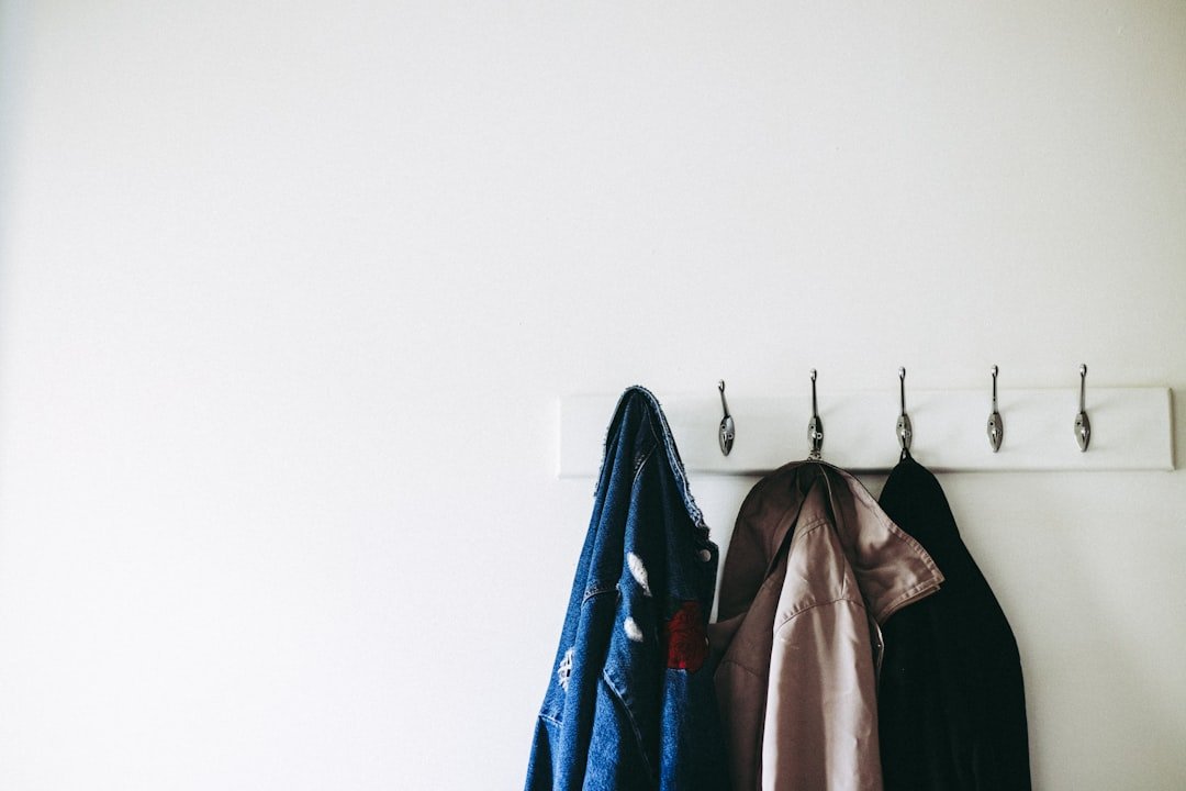 Wall hooks used for storage in a bedroom without a closet