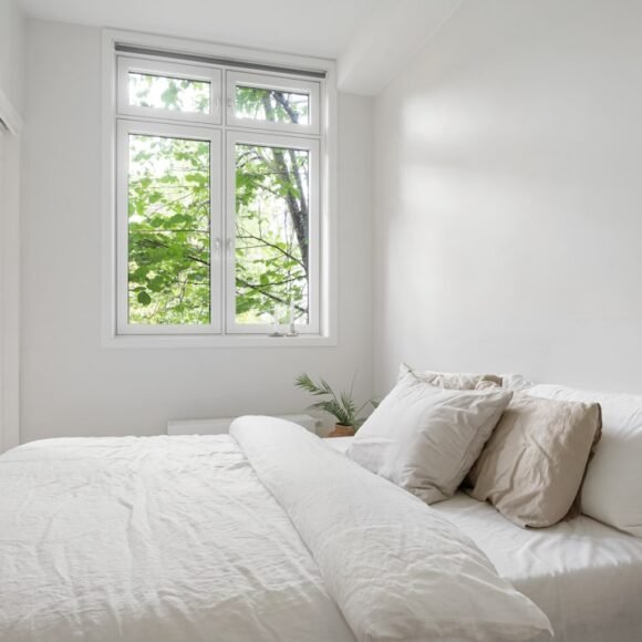 Small bright bedroom with white decor and natural light