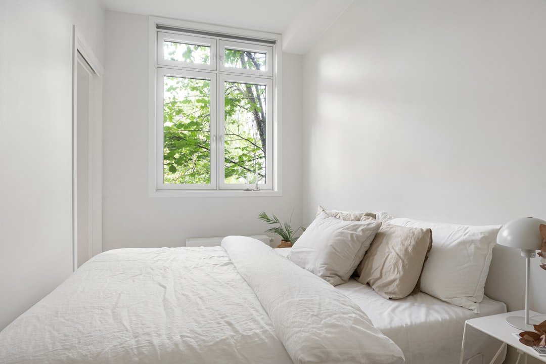 Small bright bedroom with white decor and natural light