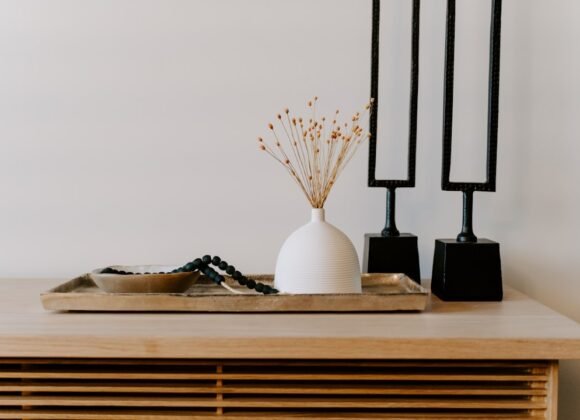 A stylish white ceramic vase styled next to decorative black table accents on a shelf, showing affordable home decor that looks custom