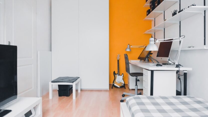 Chic Dorm Room Ideas That Don't Look Like a Dorm Small bedroom with layered neutral bedding and warm lamp light