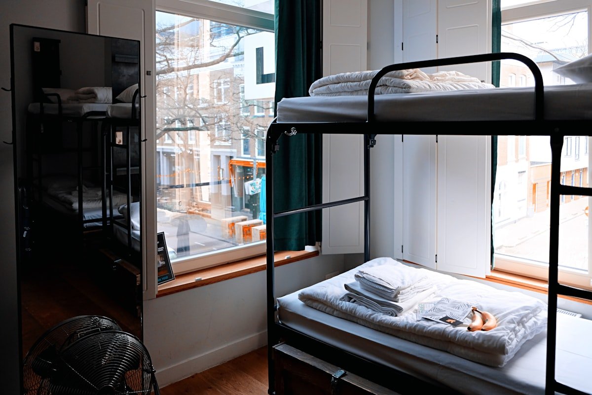 Black metal lofted bunk bed frame in a shared dorm room