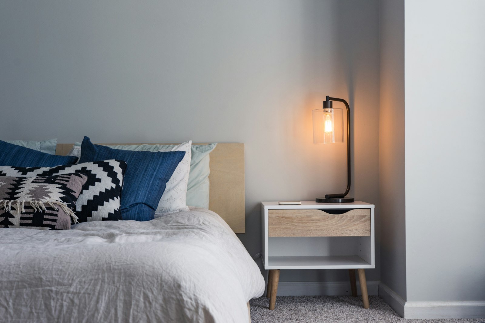 Budget bedroom decor ideas with layered bedding and warm lighting