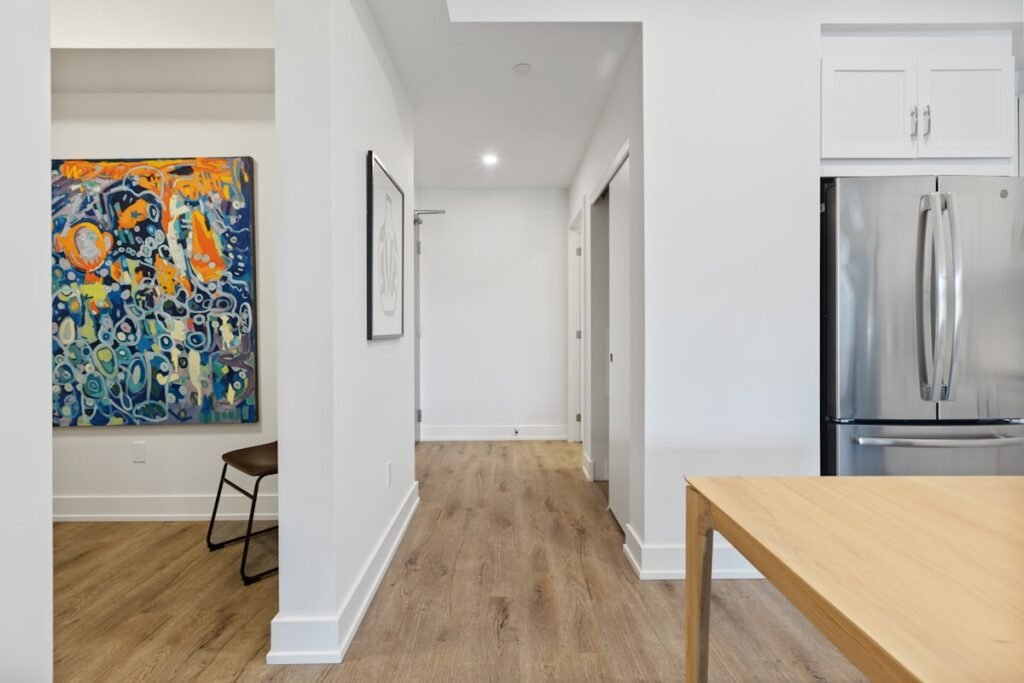 Slim wooden console table against a white entryway wall