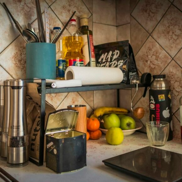 Clear kitchen counter with fruit, spices and utensils