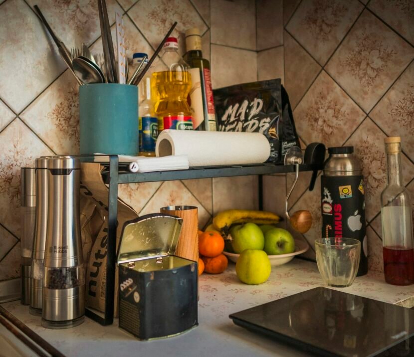Clear kitchen counter with fruit, spices and utensils
