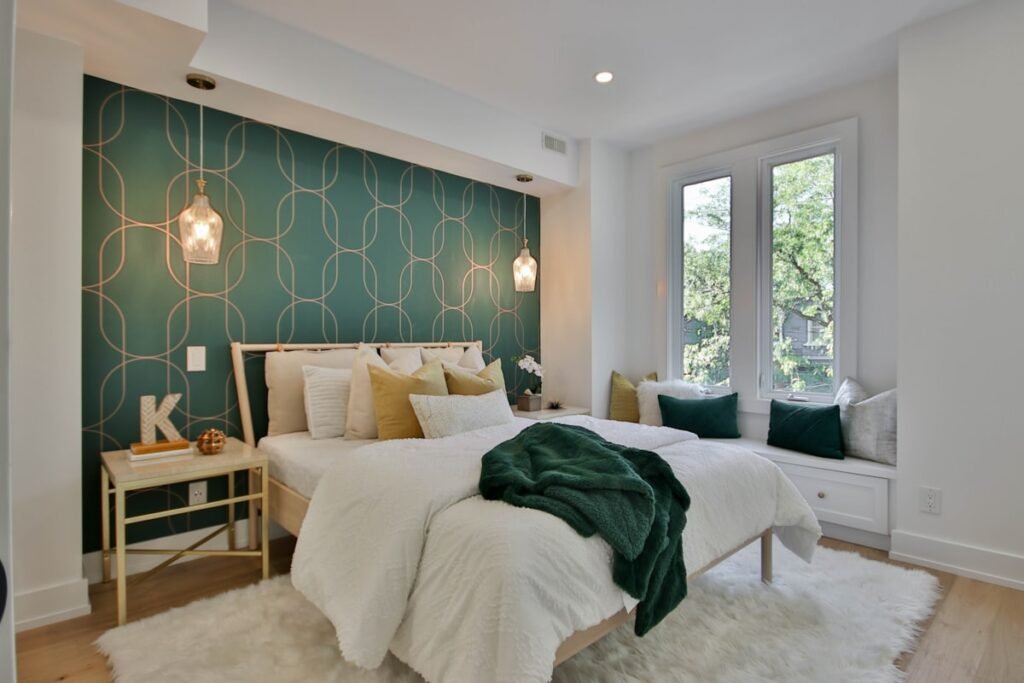 Bedroom with a deep green accent wall behind the bed