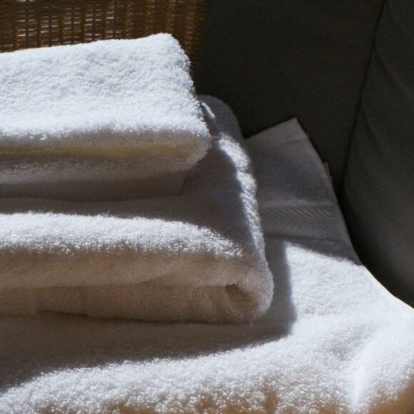 Stack of soft white towels in warm morning light