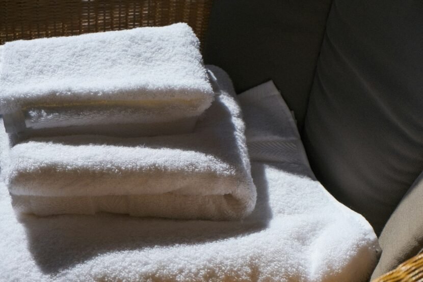 Small Bathroom Ideas That Make Tiny Bathrooms Feel Luxurious Stack of soft white towels in warm morning light