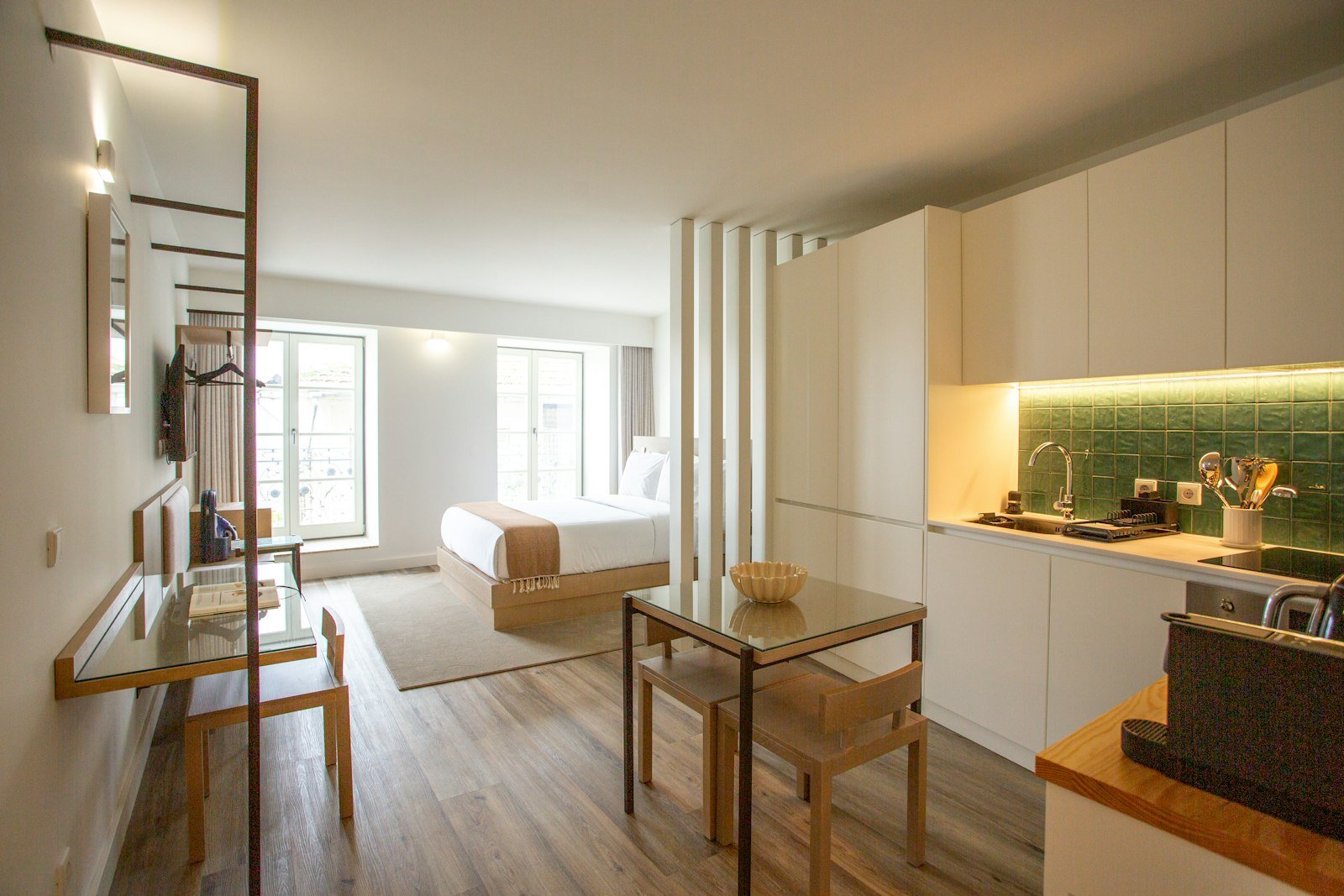 Compact dining table and chairs tucked into a studio apartment kitchen corner