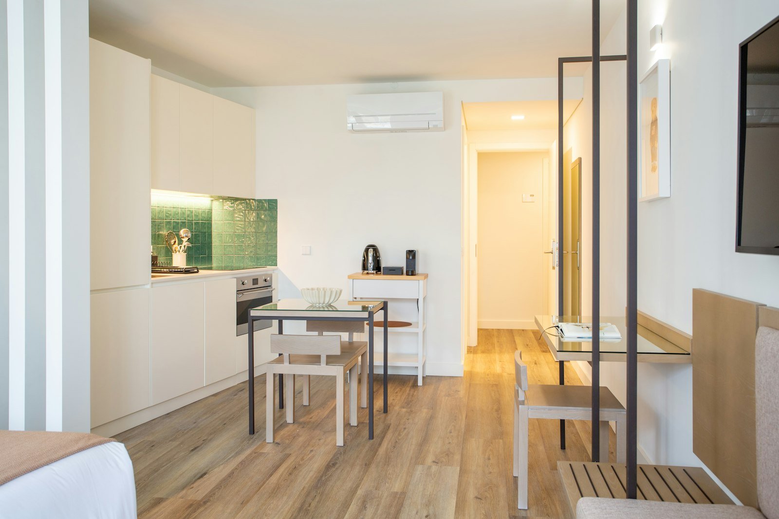 Small studio living zone with seating, low table and wall mounted television