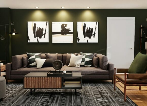 Living room with a brown sofa and patterned pillows in front of a dark green painted wall